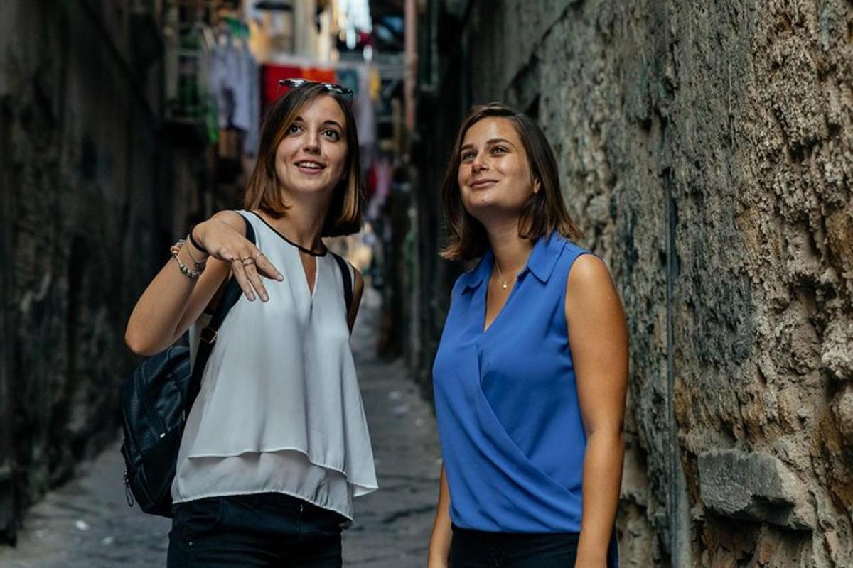 due donne sono in piedi accanto a un muro
