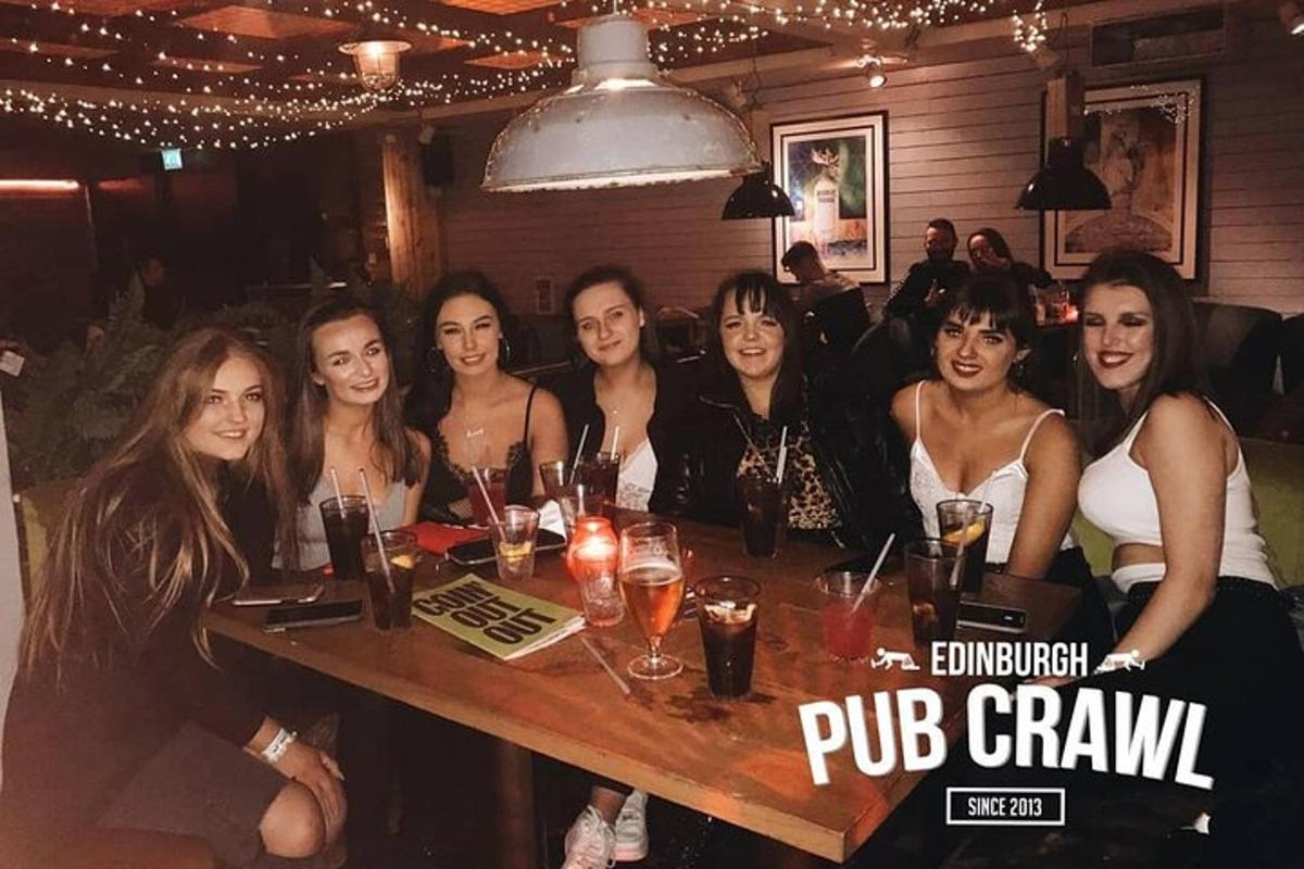 een groep mensen die aan een tafel in een bar zitten