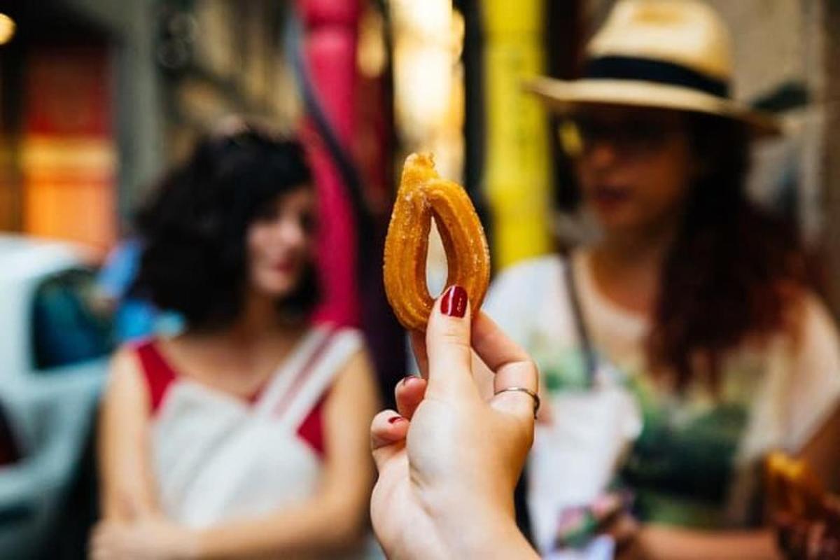 een persoon die een donut met zijn vinger omhoog houdt