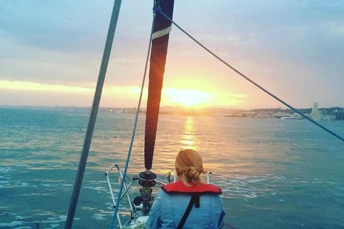 Μια γυναίκα σε μια βάρκα κοιτάζει το ηλιοβασίλεμα