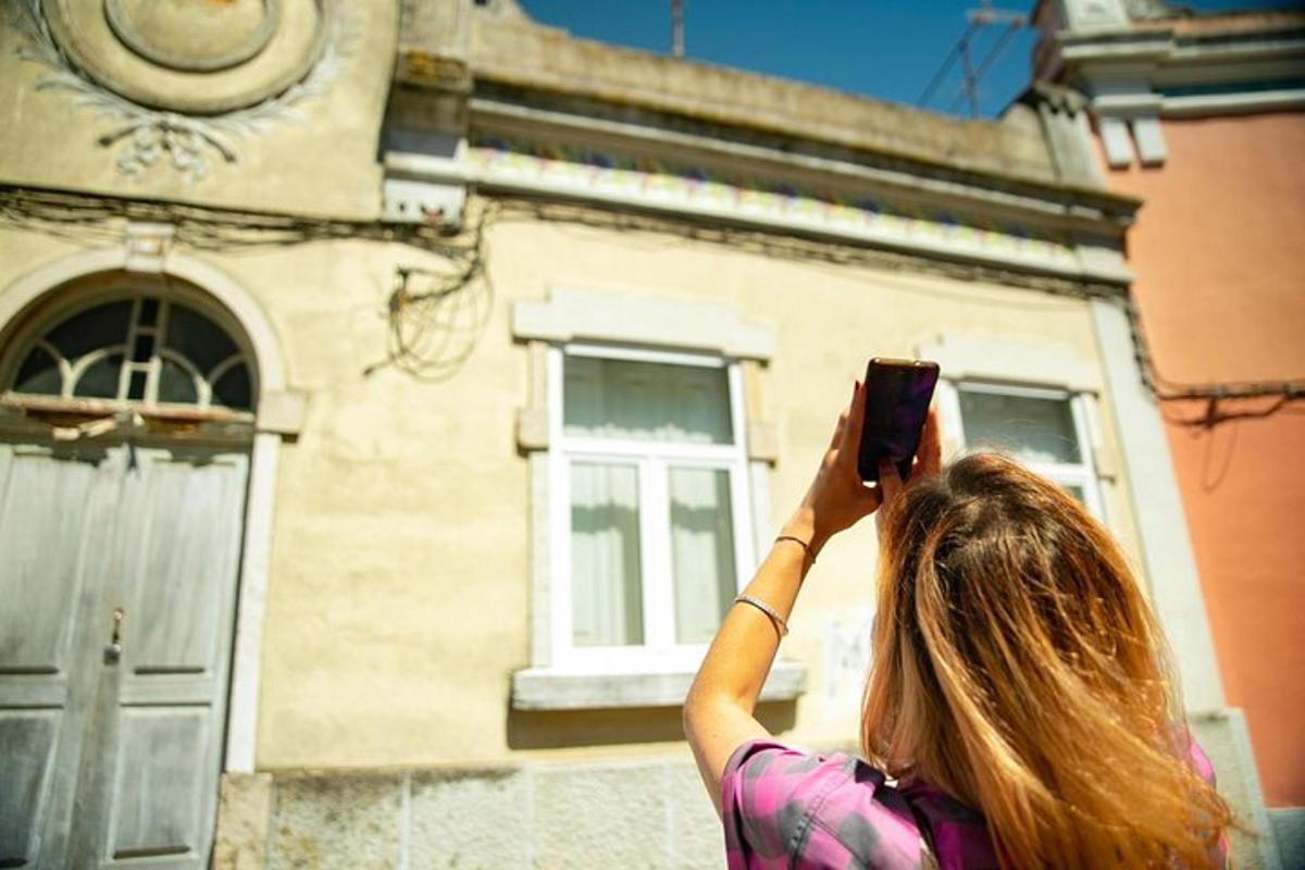 žena fotící budovu mobilním telefonem