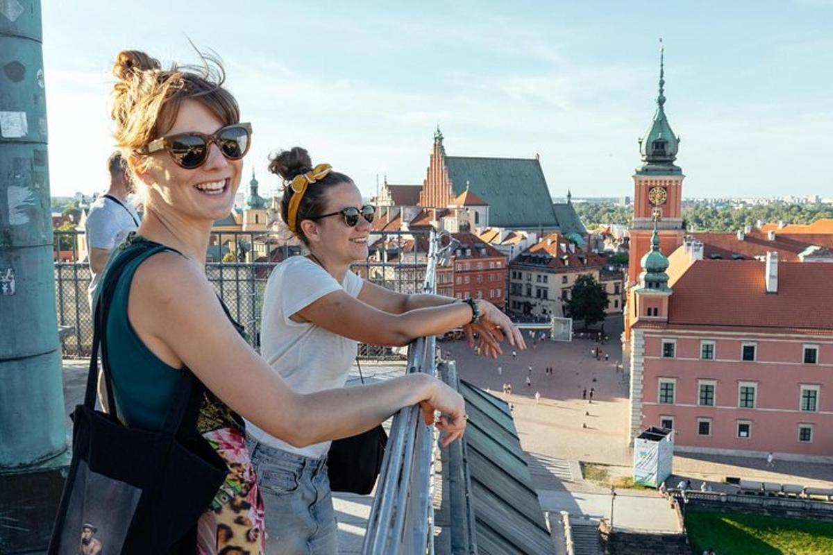 due donne in piedi su un balcone che guardano una città
