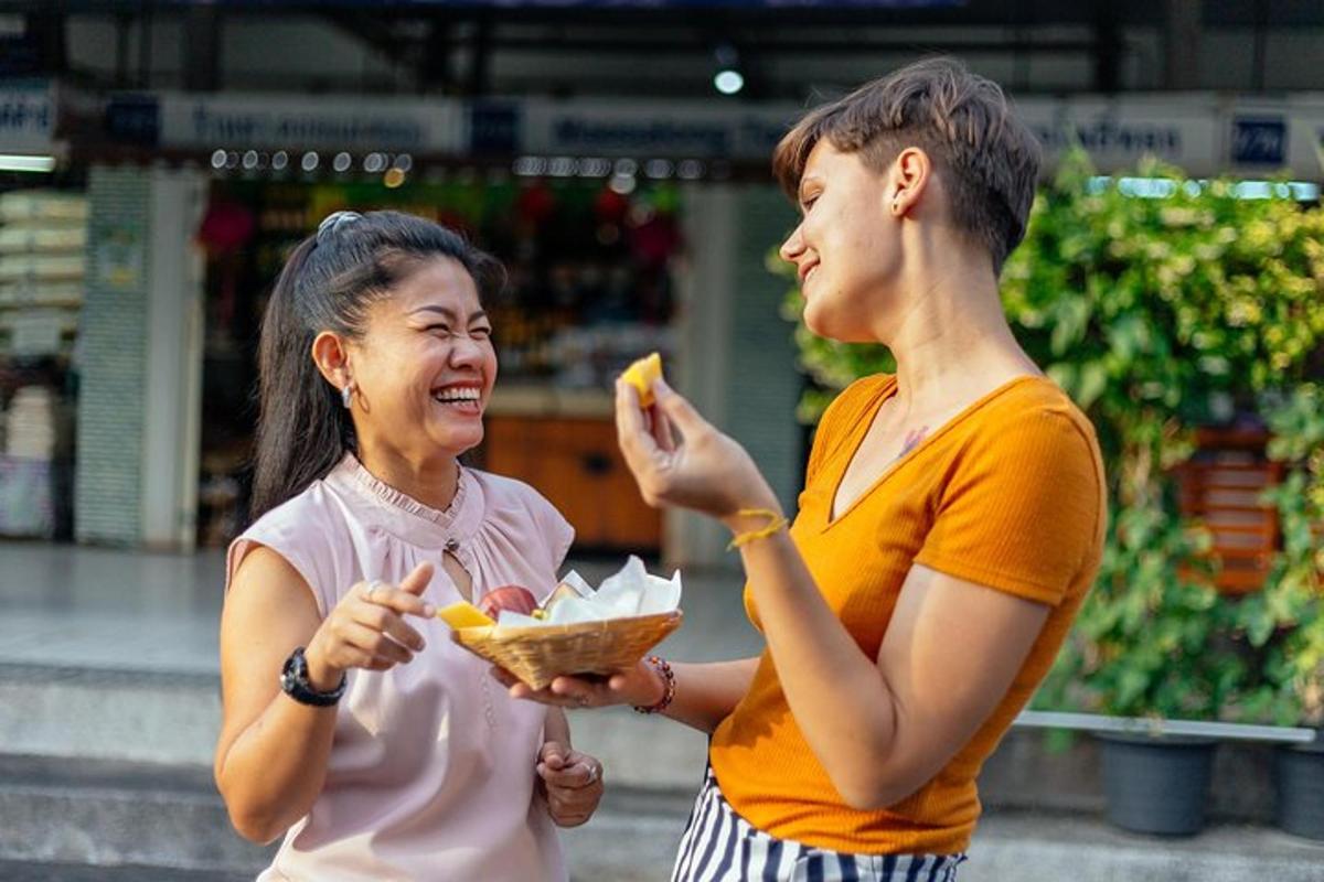 dua wanita sedang bercakap dan makan makanan di sebuah kedai