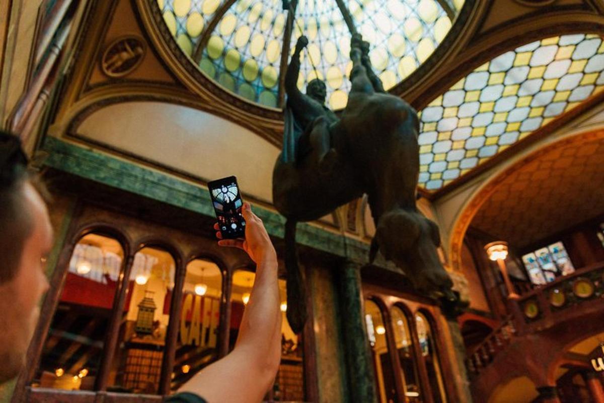 una persona che scatta una foto di una statua in un edificio