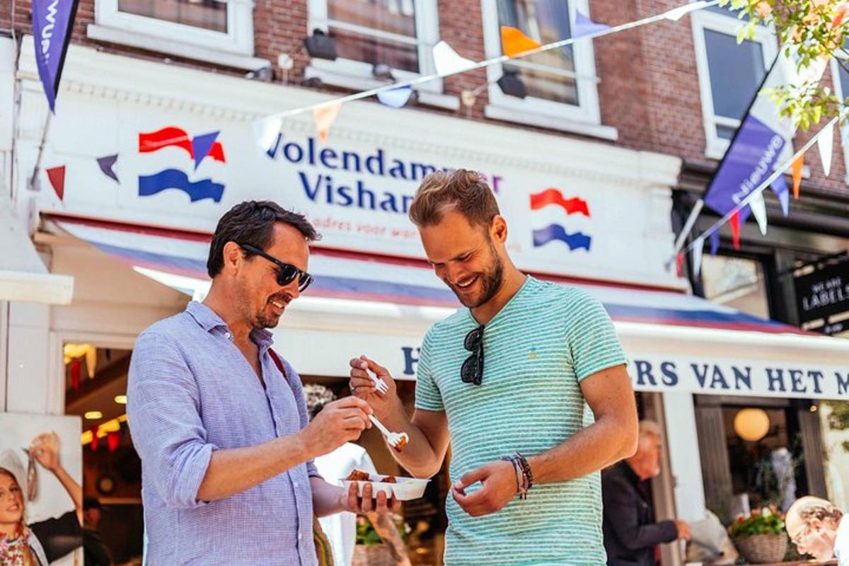 dva muži stojící vedle sebe a dívající se na mobilní telefon