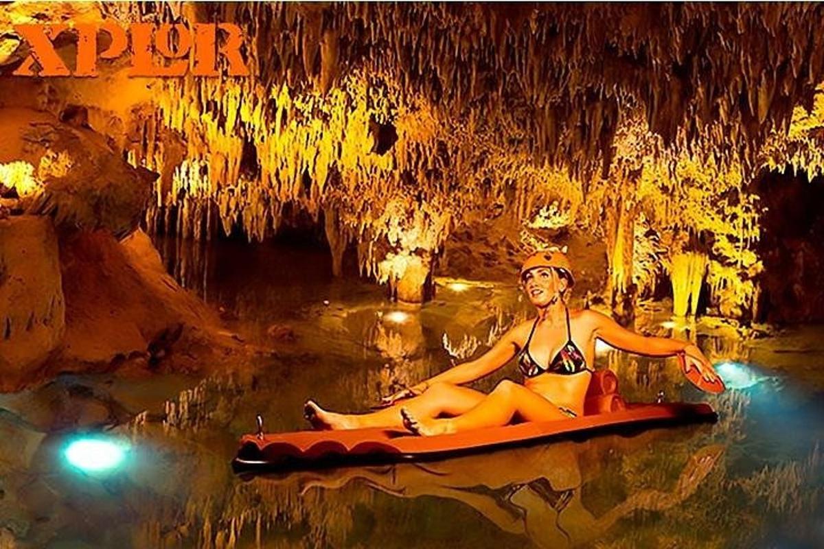 una donna seduta su un kayak in una grotta
