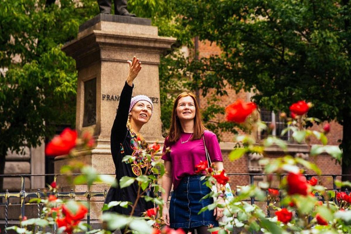 due donne in piedi davanti a un monumento con delle rose