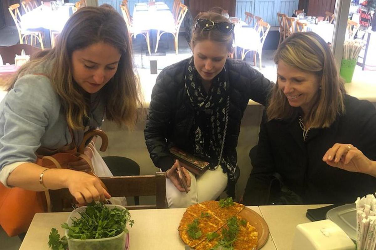 dues dones assegudes a una taula mirant un plat de menjar
