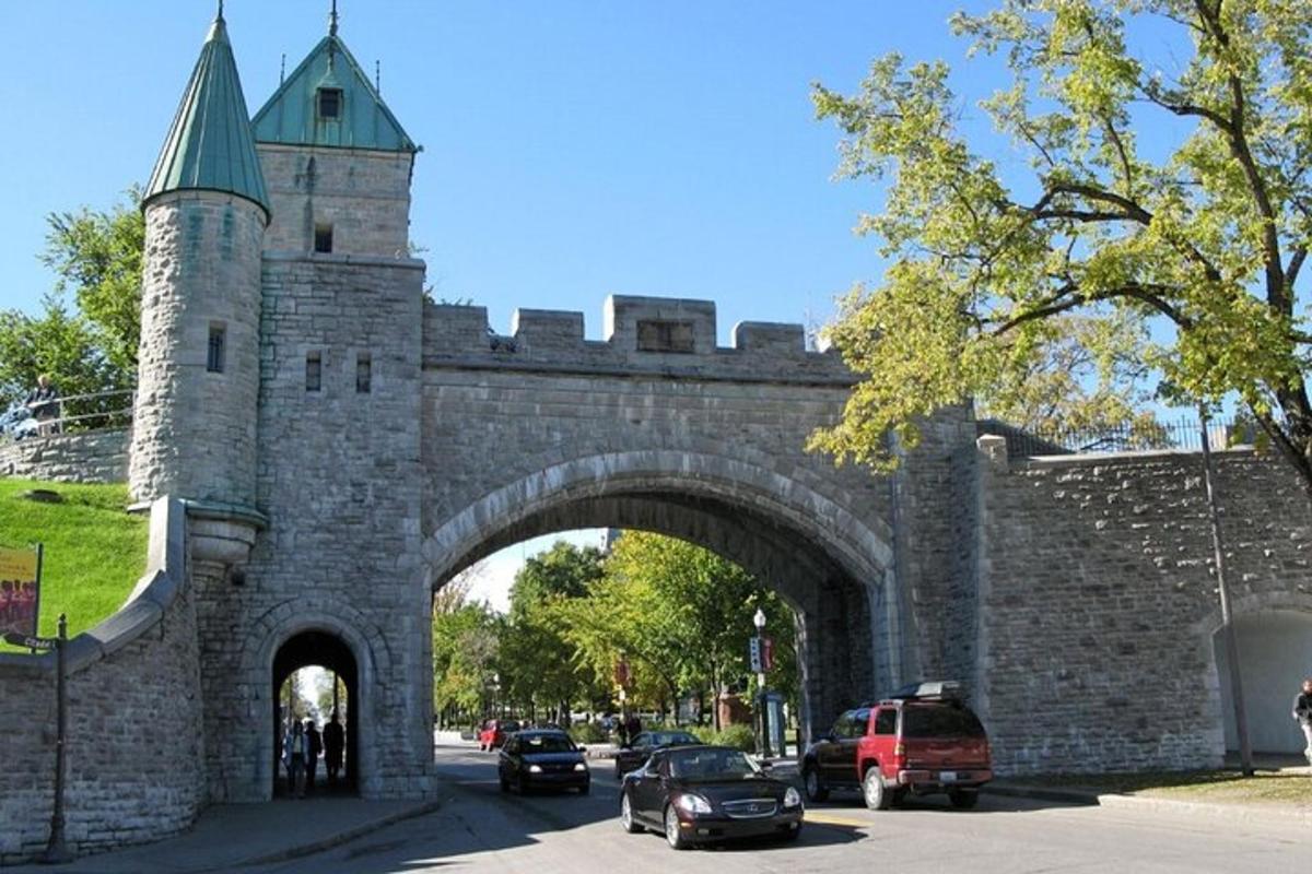 an archway in a stone building with cars parked