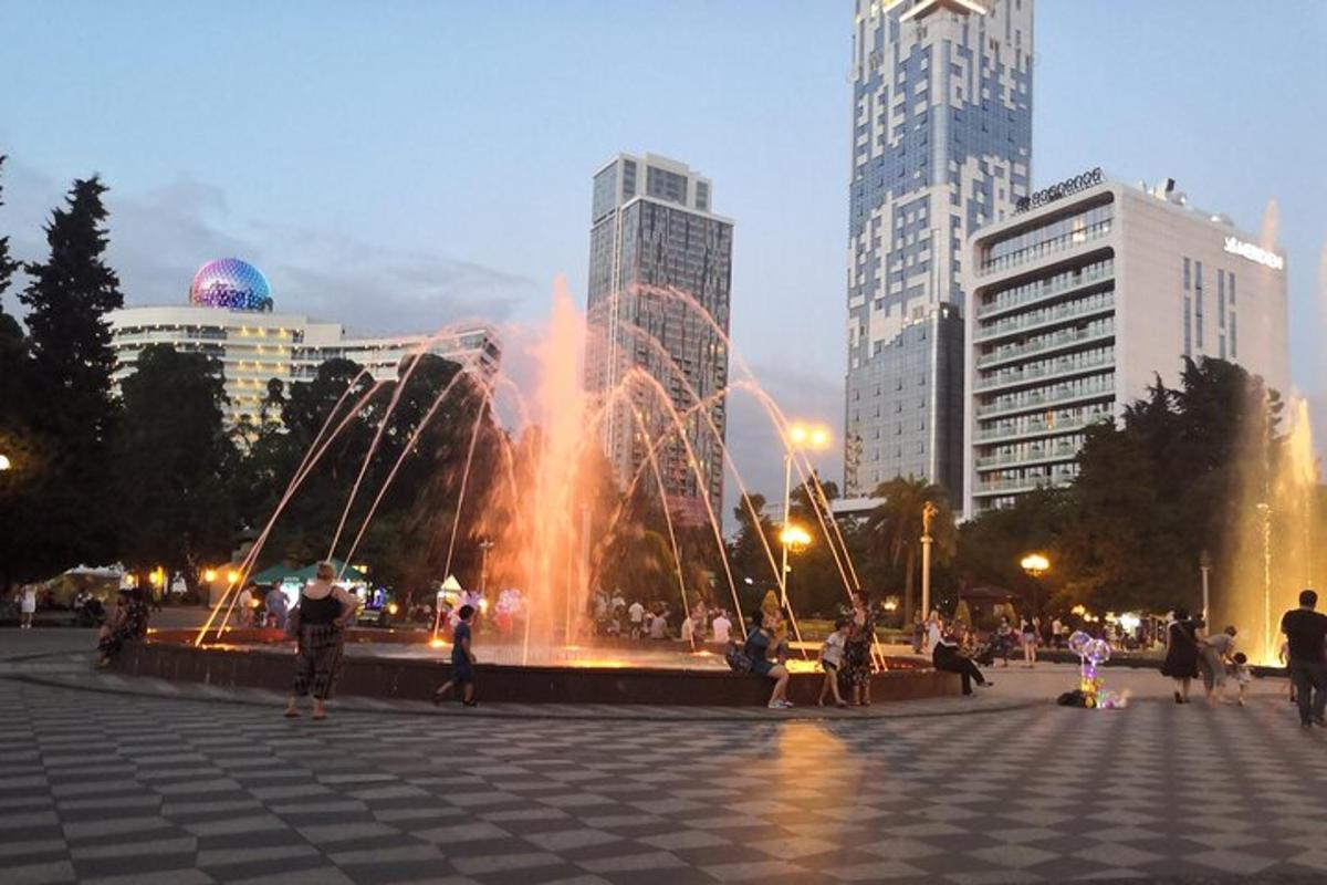 a fountain in a square in a city with tall buildings