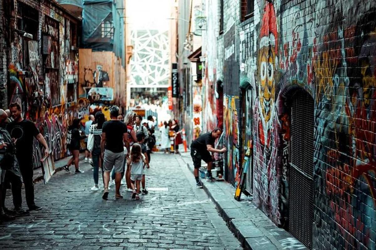 a group of people walking down a street with graffiti