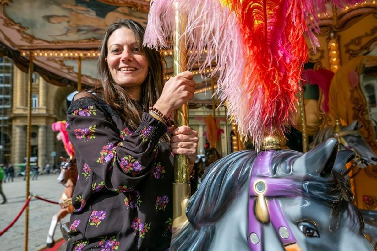 uma mulher está segurando um cavalo em um carrossel
