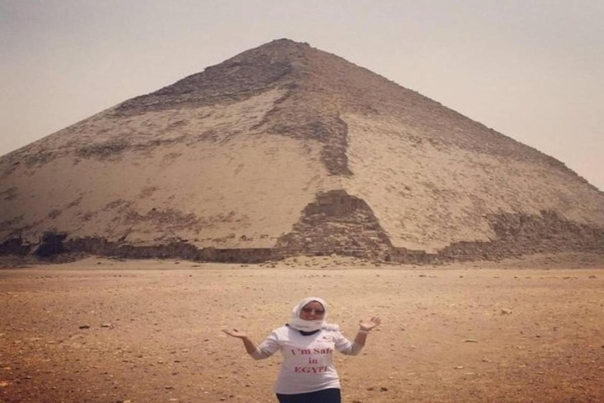 a woman standing in front of a pyramid