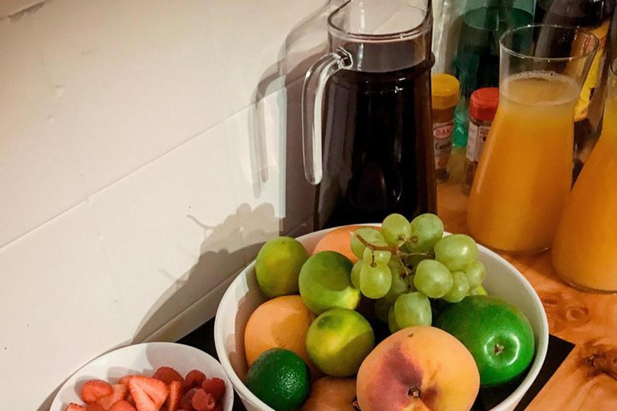 a bowl of fruit on a counter with a bowl of fruit