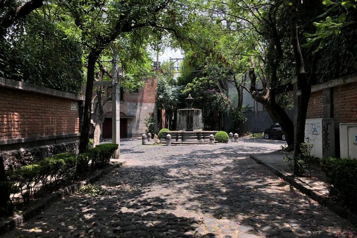 a park with a bench and a fountain and trees