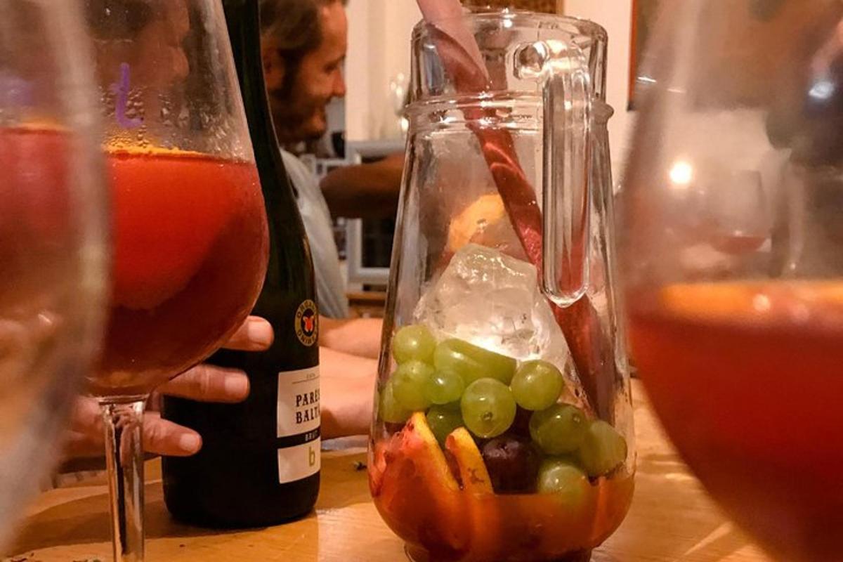 a person holding a bottle of wine and a jar of grapes
