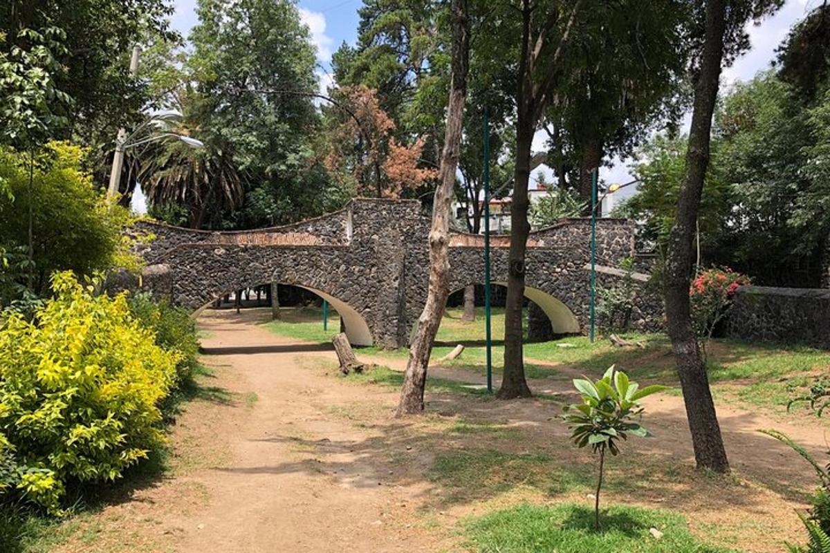a stone bridge in a park with trees