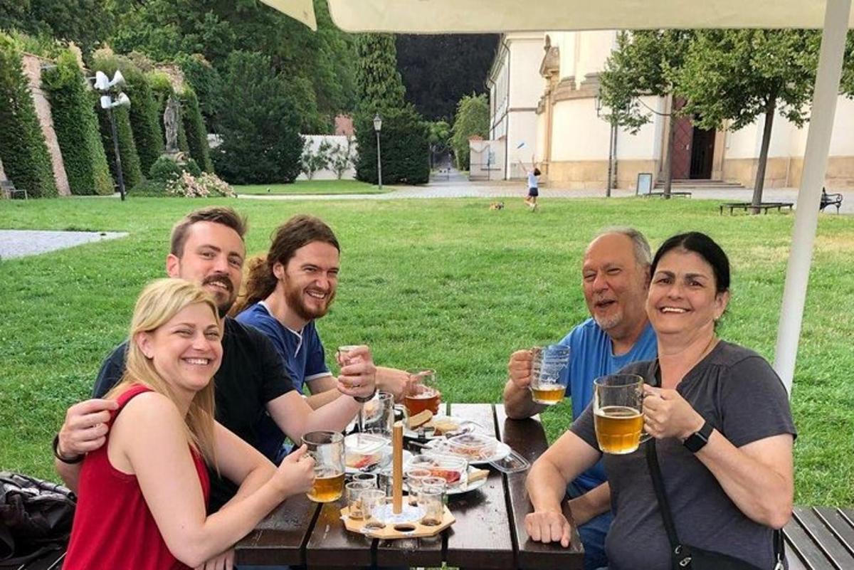 група людей сидить за столом і п'є пиво