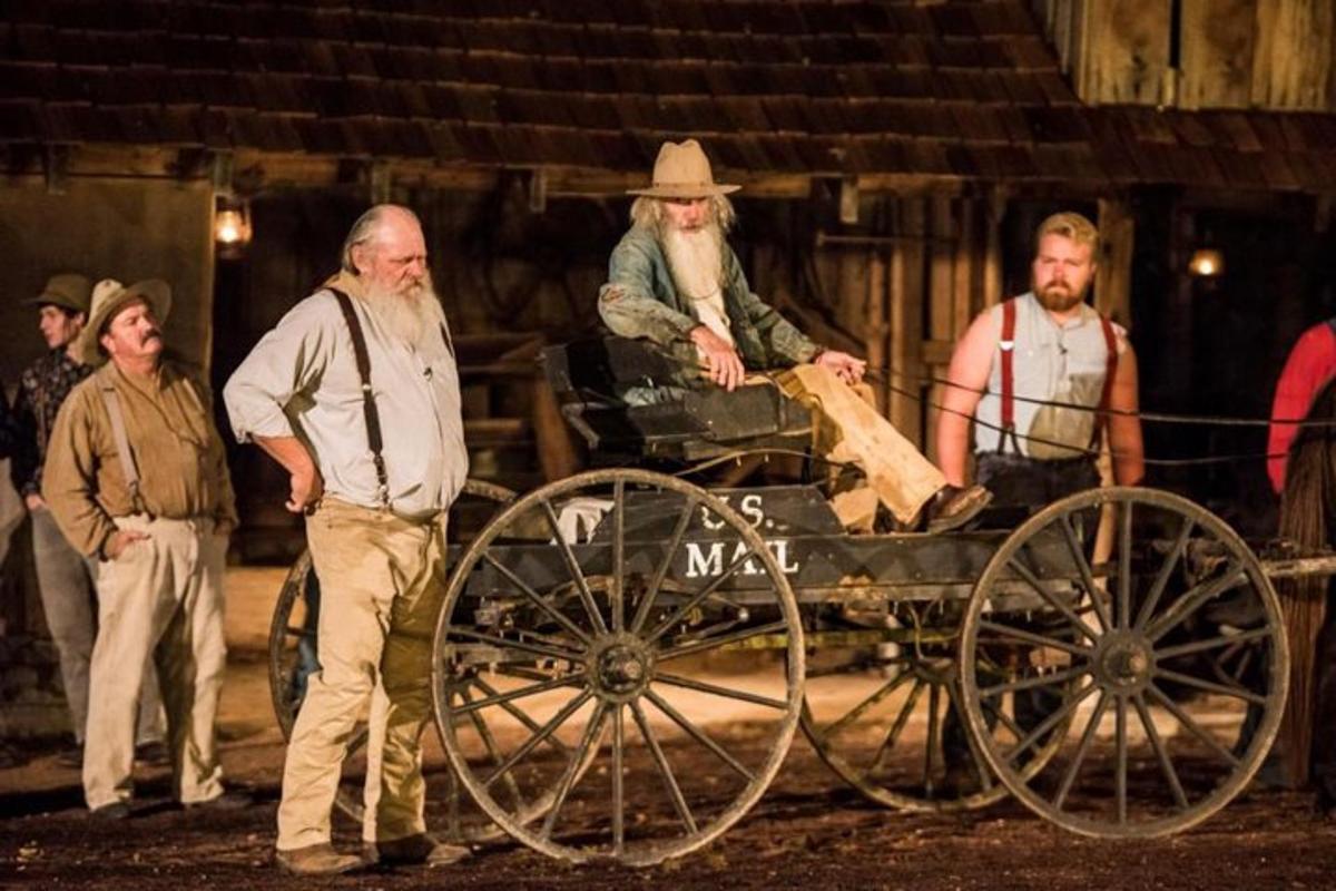 a group of men standing around a horse drawn carriage