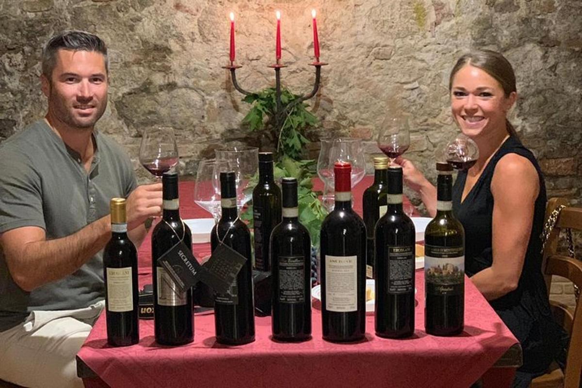 Un hombre y una mujer sentados en una mesa con botellas de vino.