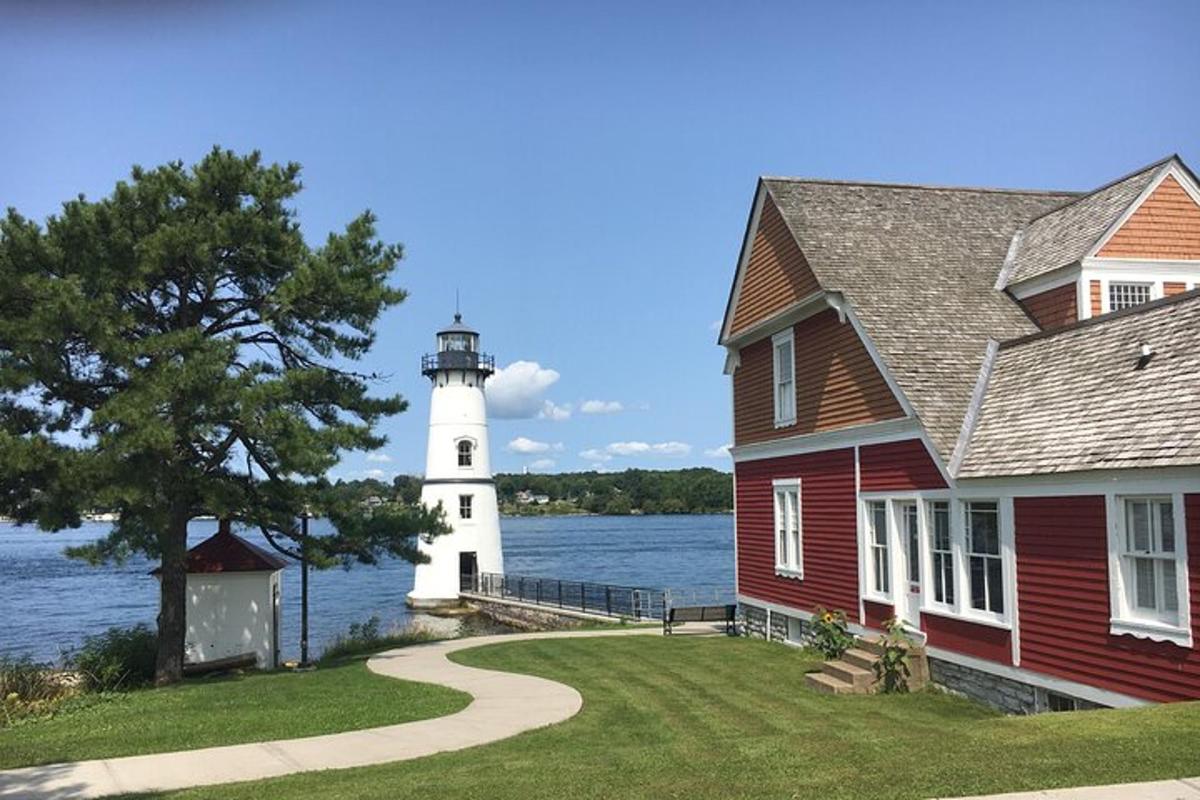 a red house with a lighthouse in the water