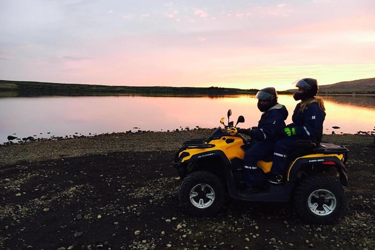 Kaks inimest istuvad ATV-l järve ääres