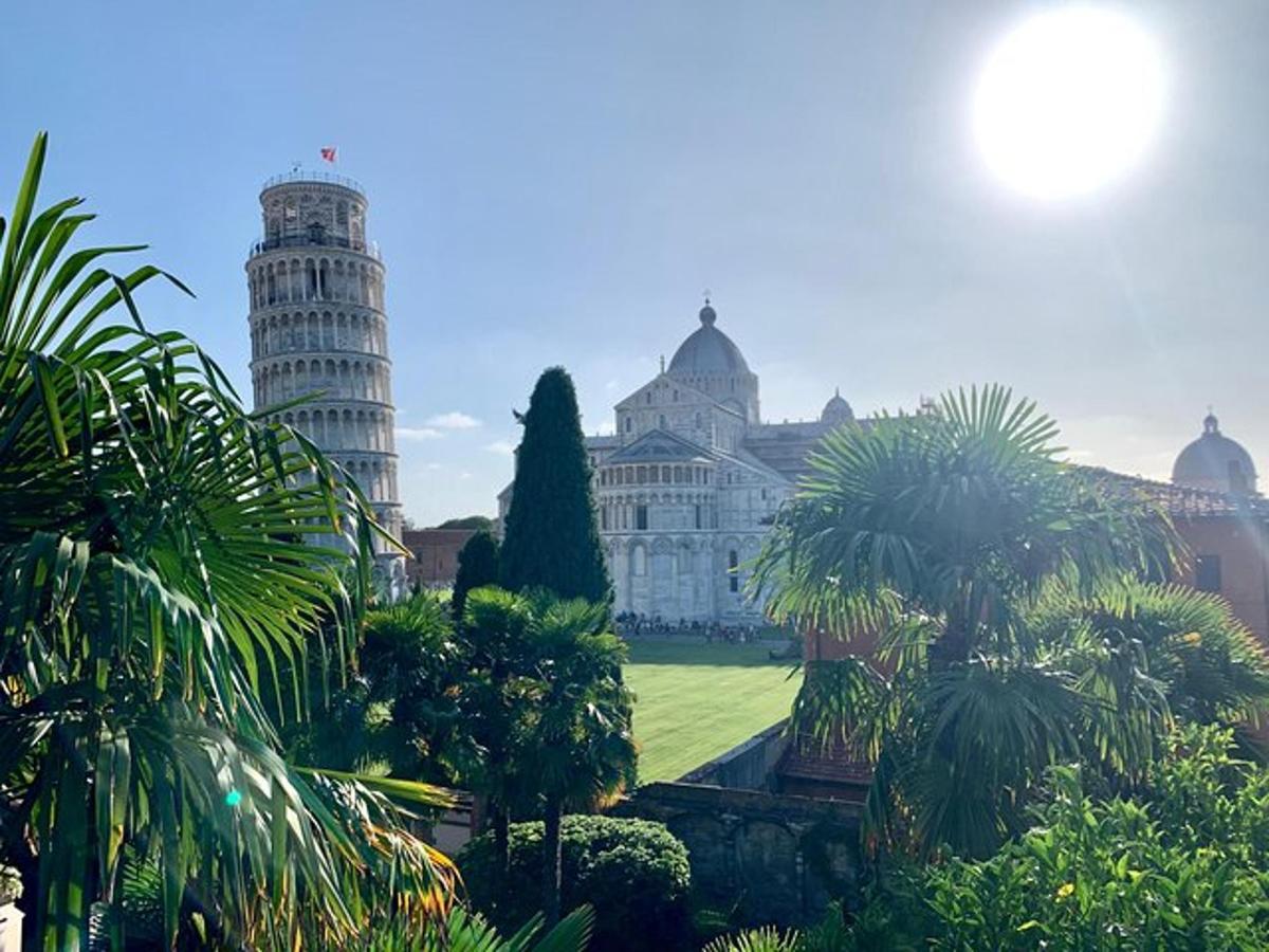 un gran edifici amb una torre del rellotge i palmeres