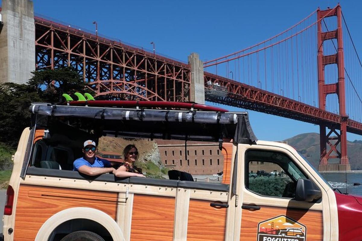 a man and woman sitting in the back of a truck with a bridge