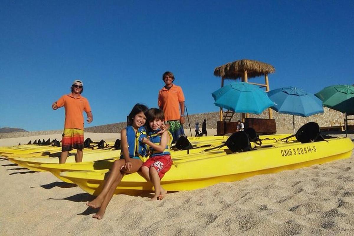 grupa ljudi sjedi na žutom kajaku na plaži