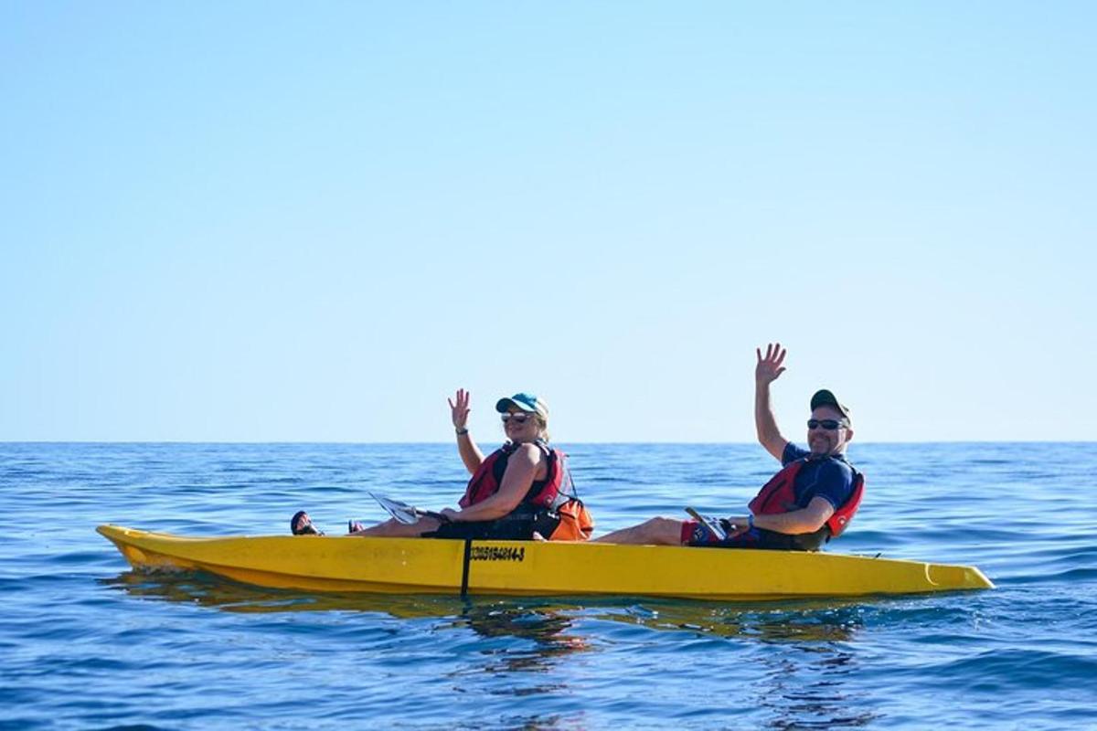 dua orang duduk di atas kayak kuning di dalam air