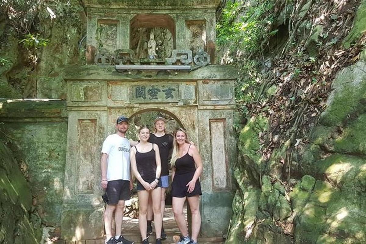 un gruppo di persone in piedi davanti a un arco di pietra