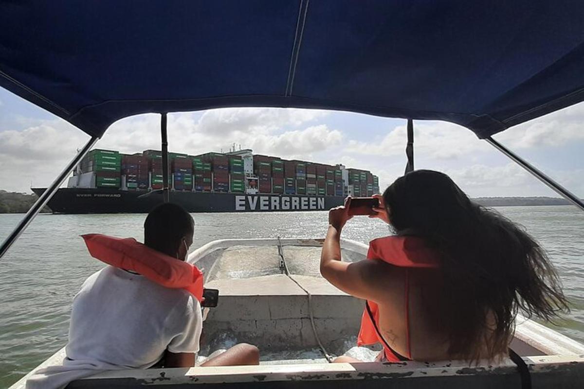 two people sitting on a boat taking a picture