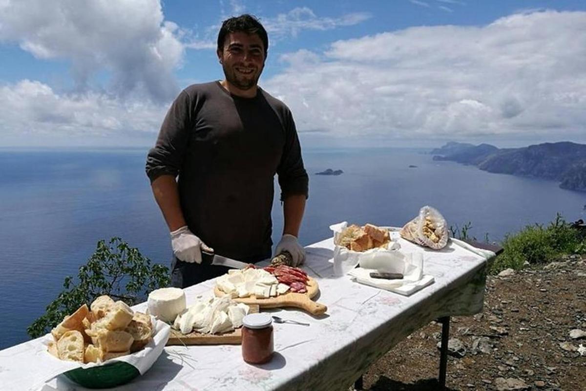 un home dret al costat d'una taula amb menjar