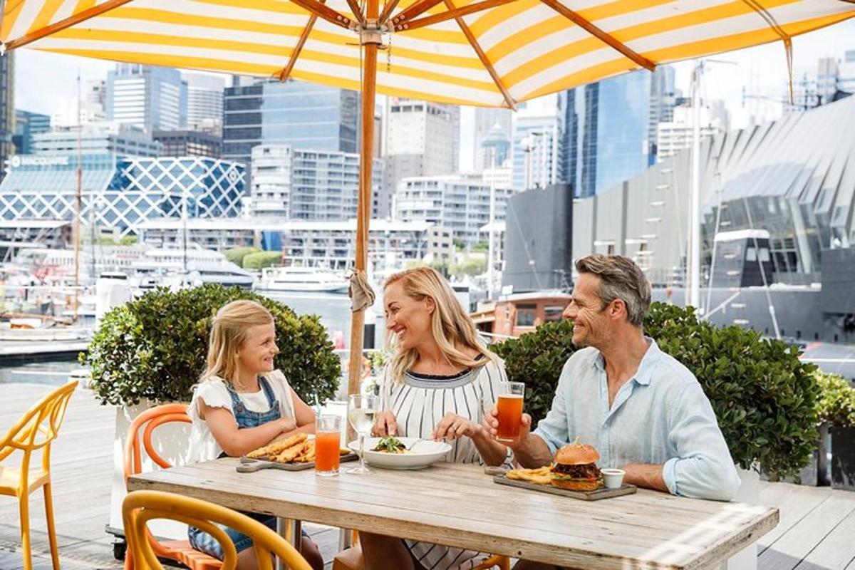 a family sitting at a table under an umbrella