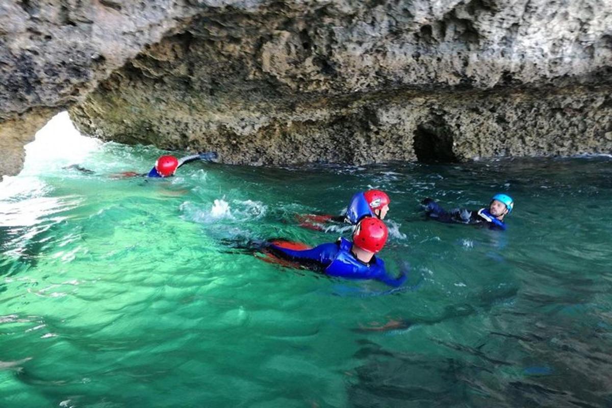 tre persone in acqua in una grotta