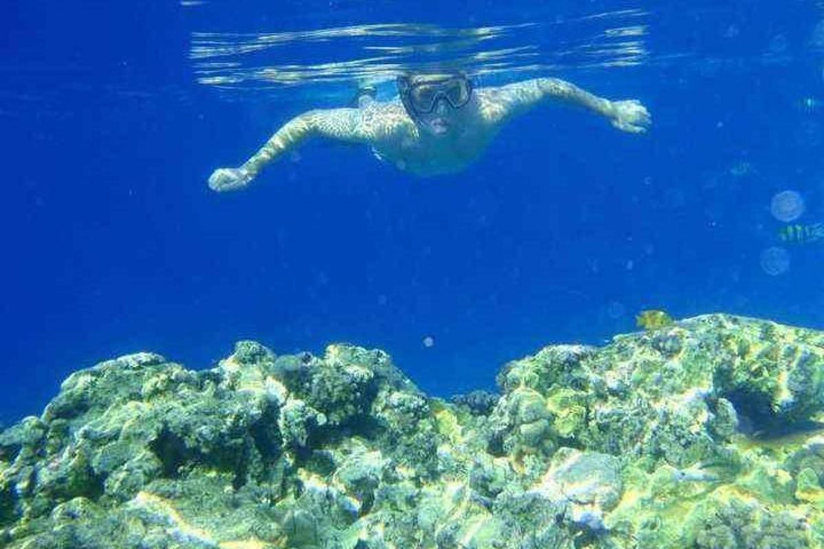 un uomo che nuota nell'acqua con gli occhialini