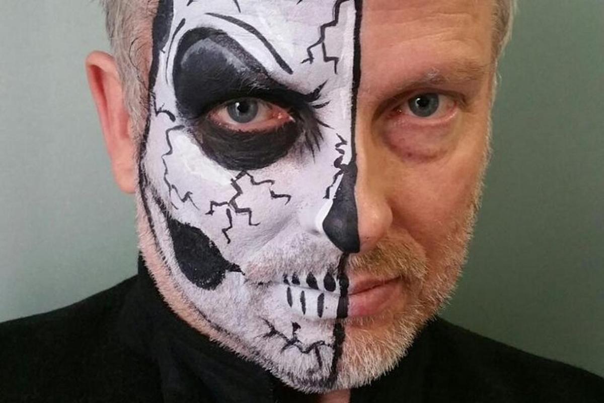 a man with a face painting of a sugar skull