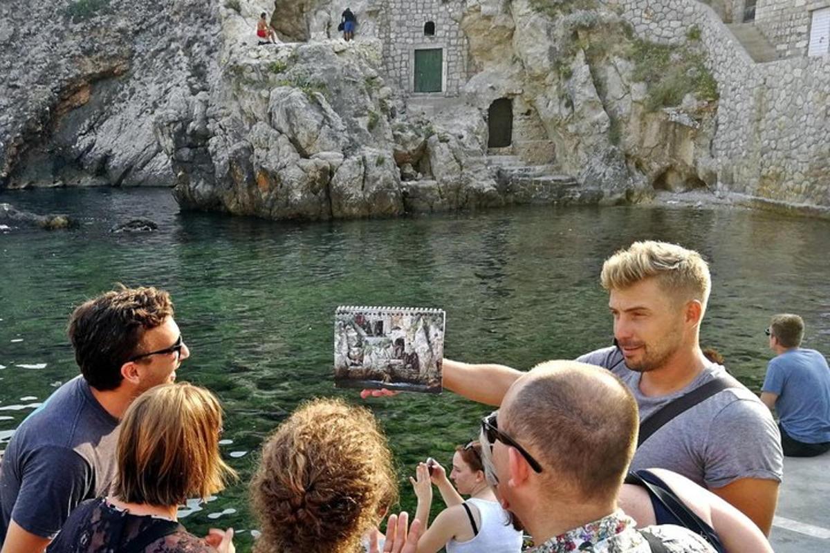 un home que sosté una foto d'un grup de persones a l'aigua