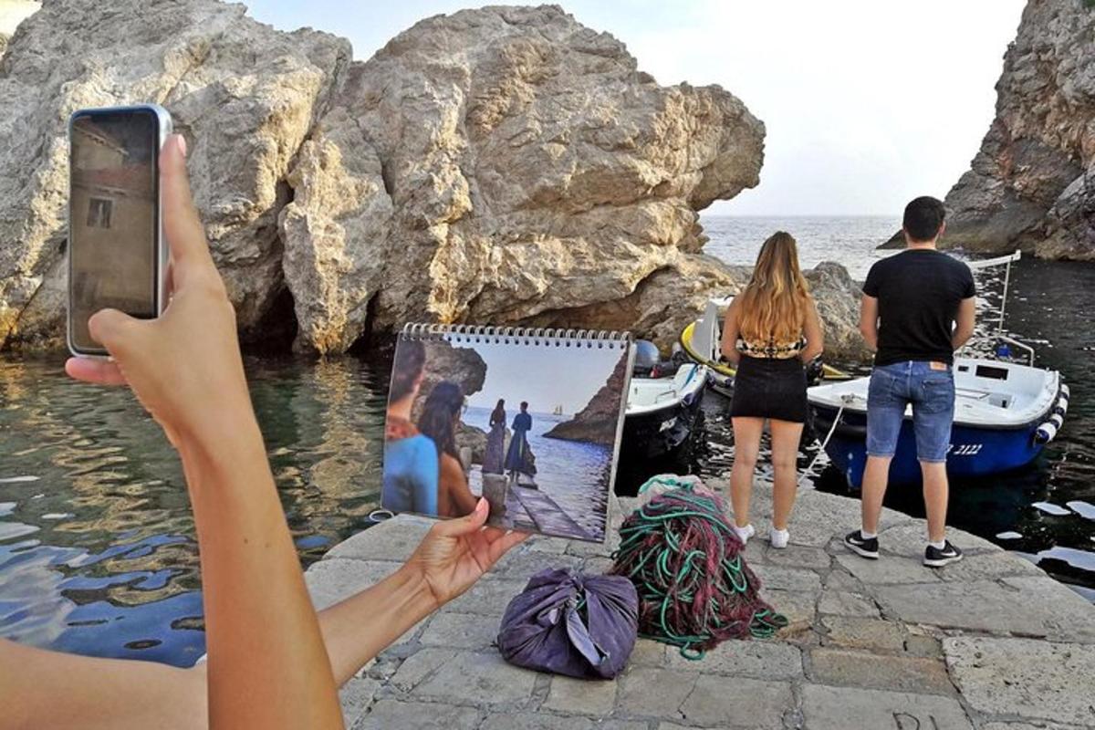 una persona fent una foto de l'oceà amb un telèfon mòbil