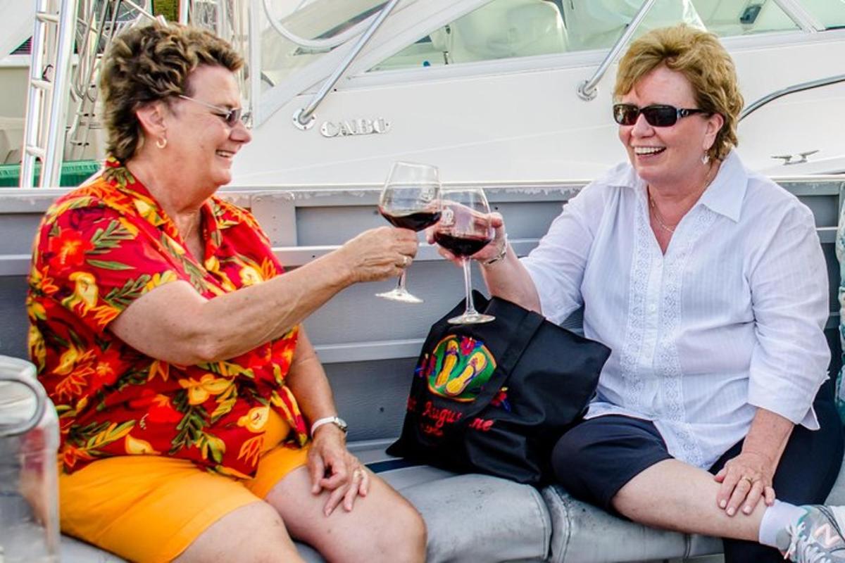 due donne sedute su una barca che bevono vino