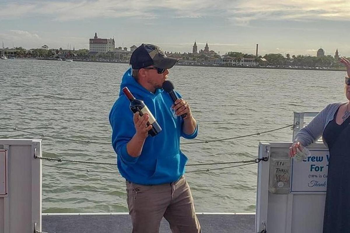un uomo in piedi su una barca che tiene in mano un microfono