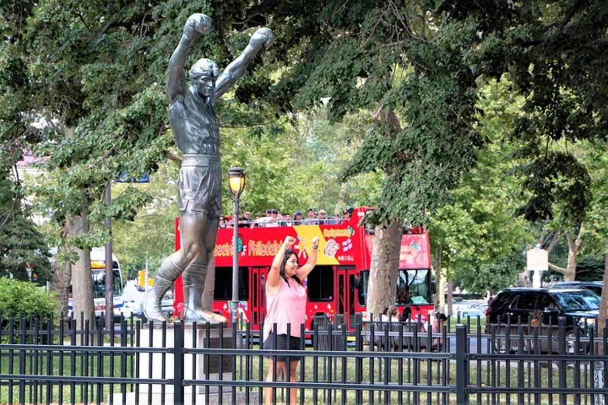una donna che scatta una foto alla statua di un uomo