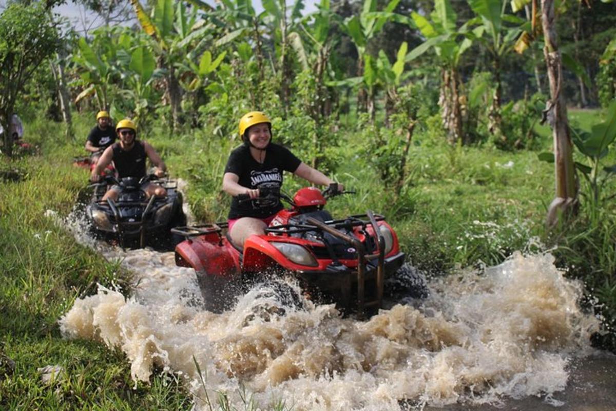 sekumpulan orang menunggang atv melalui sungai
