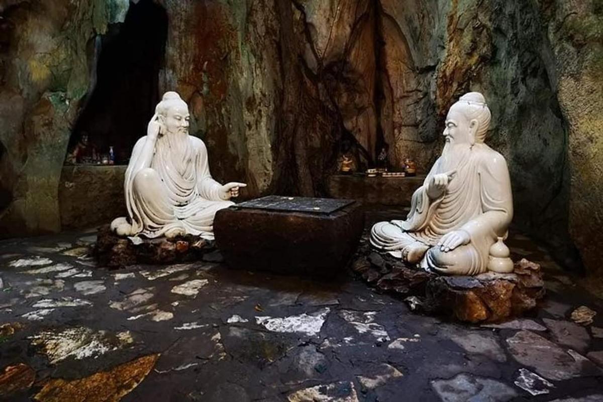 tre statue bianche sedute sulle rocce in una grotta