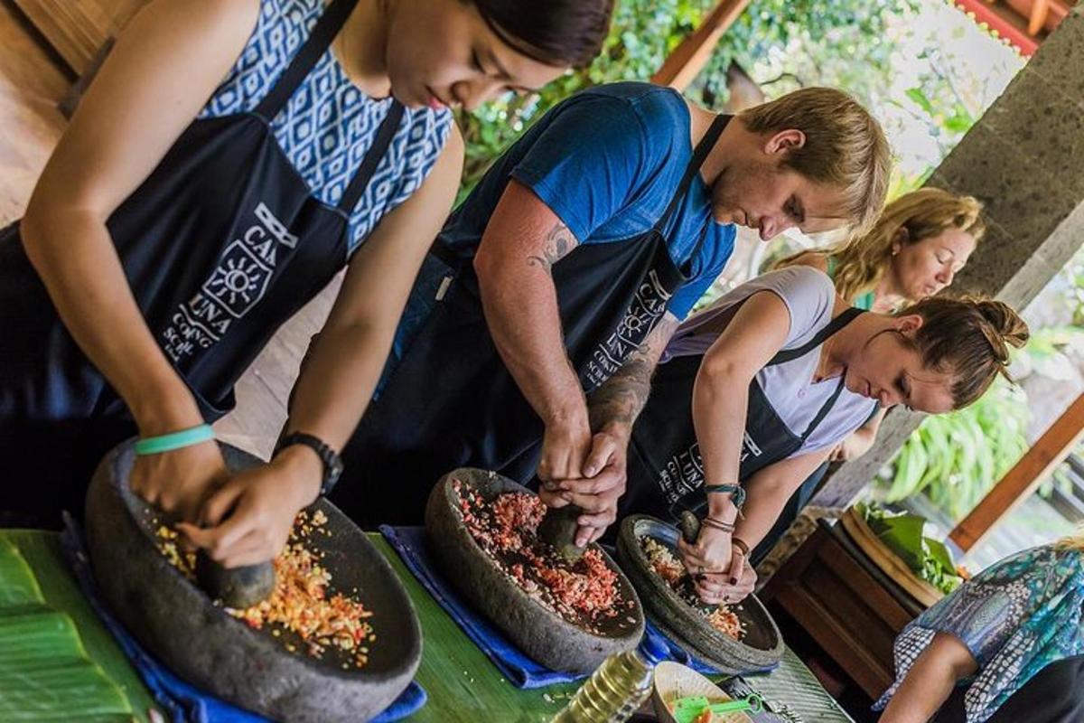 a group of people preparing pizzas on a table