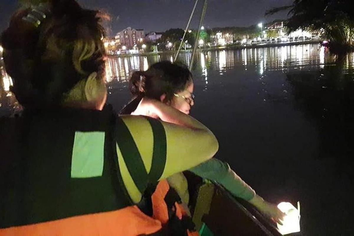duas pessoas em um barco na água à noite