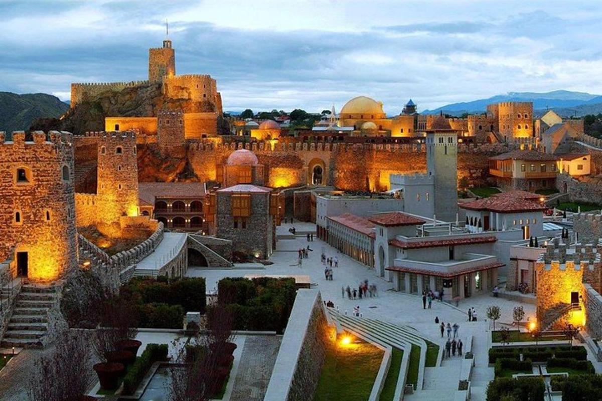 o vedere a unui oraș noaptea cu un castel