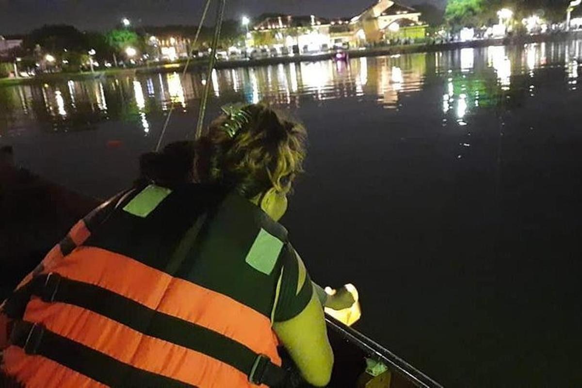 uma mulher em um barco na água à noite