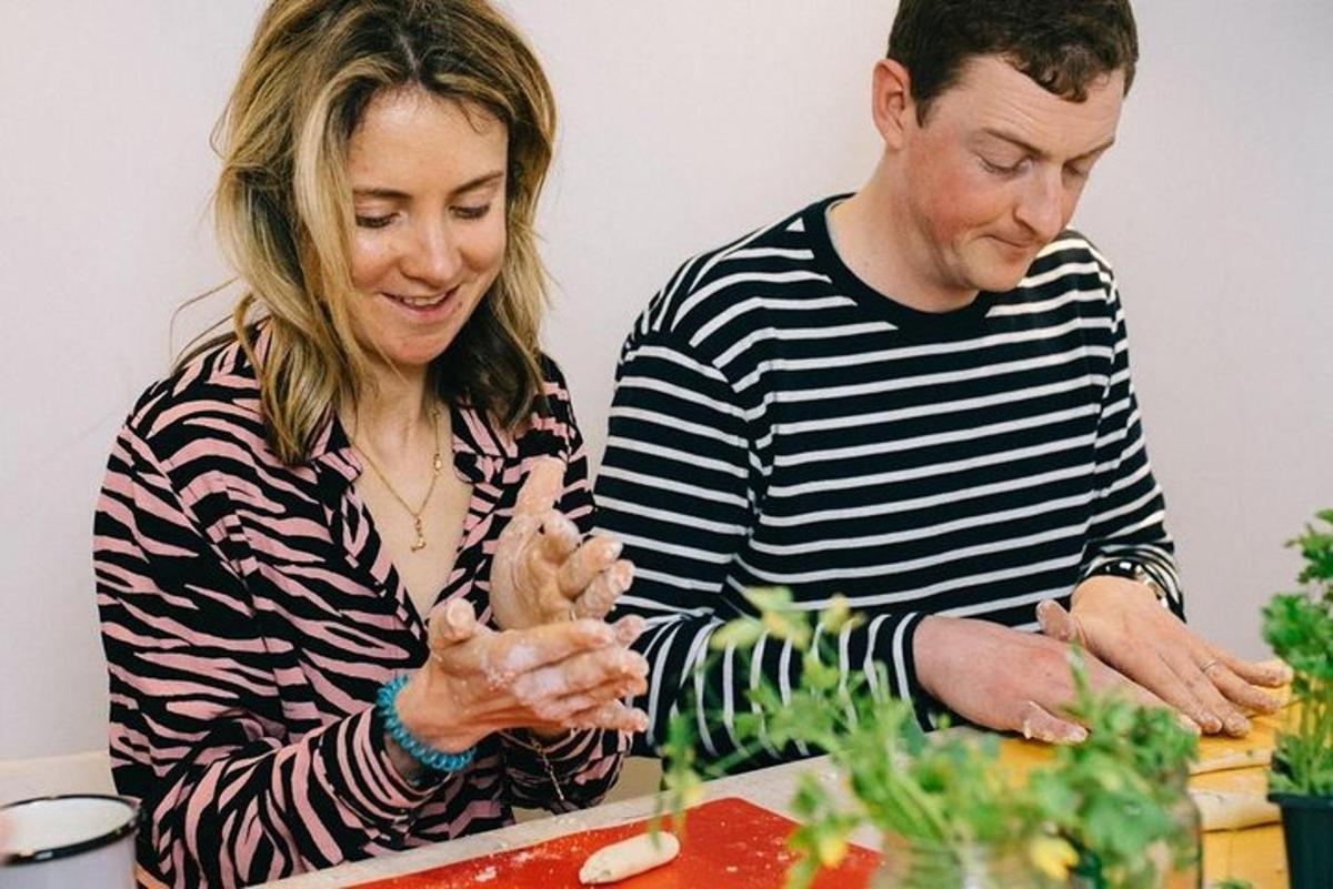 a man and a woman preparing food on a table