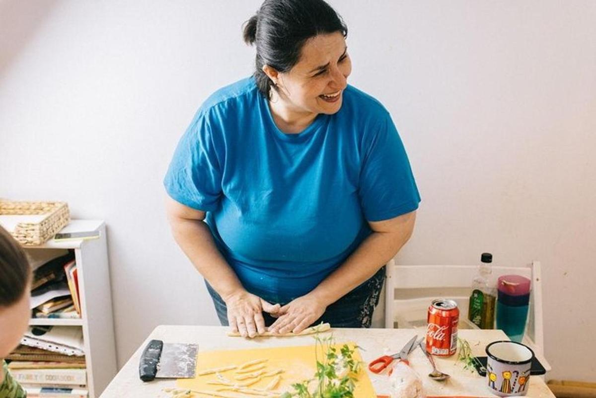 a woman standing at a table cutting a cake